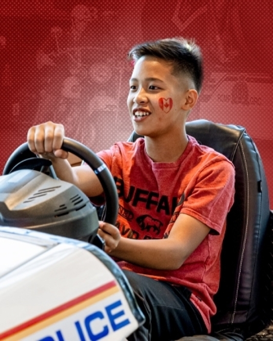 Kid driving a police themed driving simulator