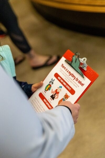 Person holding a Maple Mystery activity worksheet.
