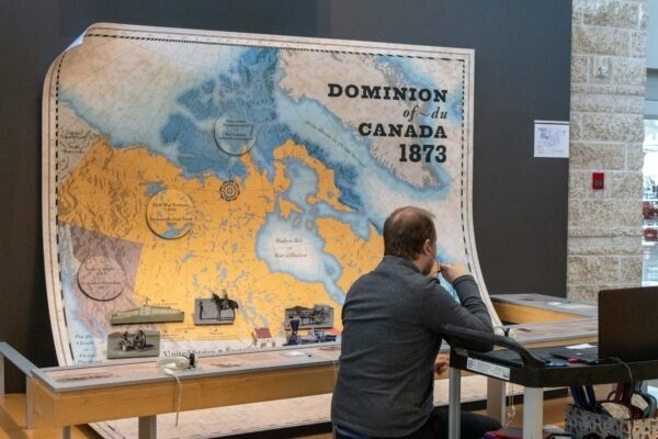 Visitor exploring a Dominion of Canada map exhibit.