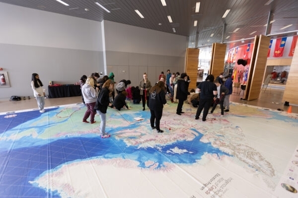 Students participate in an educational floor map activity.