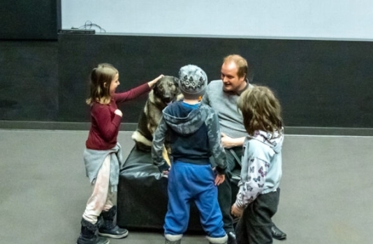 Children meet a dog during an educational presentation.